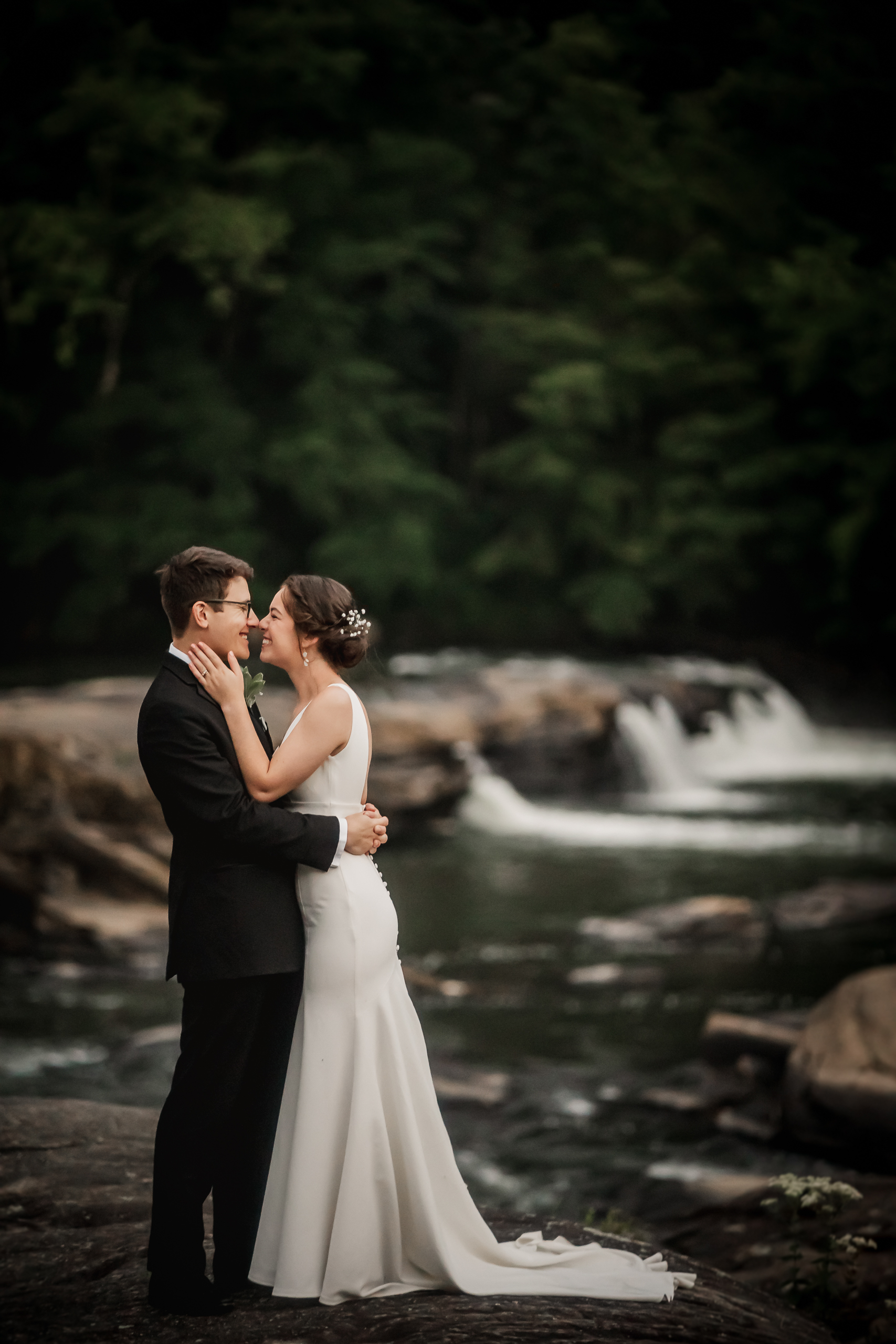 Bride and Groom on their wedding day standing in front of a waterfall